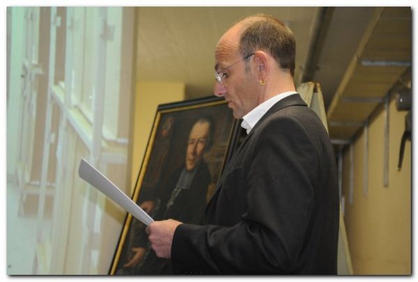 100604 Oel auf Leinwand II 033 Vortragender mit einem Gemälde im Hintergrund