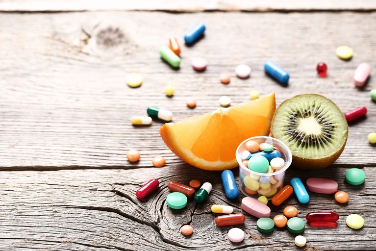 Ripe fruits and colorful pills on wooden table Ripe fruits and colorful pills on wooden table