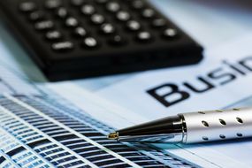 Taschenrechner, Stift und Notizblock