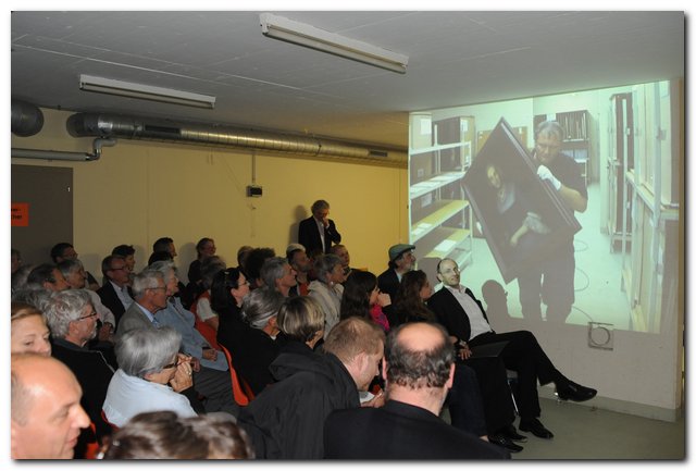 100604 Oel auf Leinwand II 015 Gespannte Zuhörer mit Bildern die an die Leinwand projiziert werden